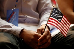 A new citizen holds a U.S. flag at the U.S. Citizenship and Immigration Services (USCIS) naturalization ceremony at the New York Public Library in Manhattan,
