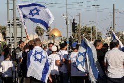 Israelis walk with flags outside Jerusalem's Old City,
