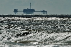 An oil and gas drilling platform stands offshore in Dauphin Island, Alabama