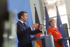 French President Emmanuel Macron speaks as he and German Chancellor Angela Merkel give a news statement in Berlin, Germany,