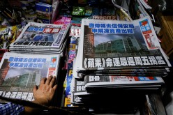 Copies of the Apple Daily newspaper are seen at a newspaper stall after it looked set to close for good