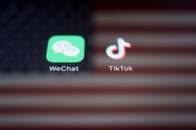 A reflection of the U.S. flag is seen on the signs of the WeChat and TikTok apps in this illustration picture taken 