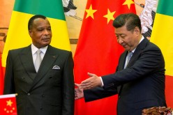 Chinese President Xi Jinping, right guides Congo Republic President Denis Sassou Nguesso to his seat during a signing ceremony