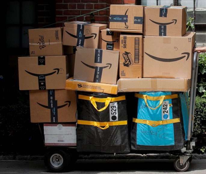An Amazon delivery worker pulls a delivery cart full of packages during its annual Prime Day promotion in New York City, U.S
