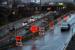 Cars drive along the NJ 495 route while road work signs are seen on the roadside, in Union City, New Jersey, U.S.