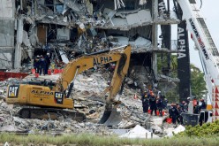 Emergency workers conduct search and rescue missions at the site of a partially collapsed residential building in Surfside, near Miami Beach, Florida, U.S