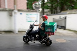 A delivery worker of Chinese online grocery Dingdong Maicai is seen on a street in Shanghai,