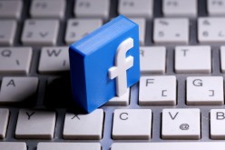 A 3D-printed Facebook logo is seen placed on a keyboard in this illustration taken 