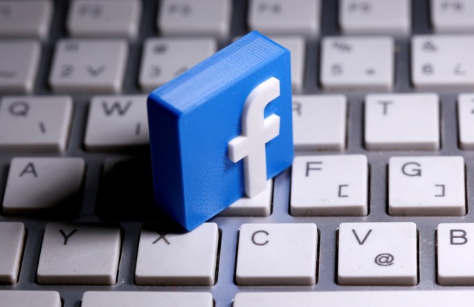 A 3D-printed Facebook logo is seen placed on a keyboard in this illustration taken 