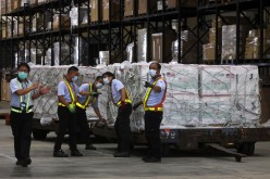 Workers transport Moderna vaccines against the coronavirus disease (COVID-19) shipped from the United States,