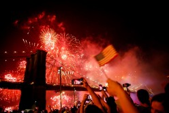 People watch the Macy's 4th of July Firework Show over the Brooklyn Bridge in New York,