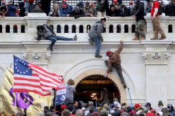 A mob of supporters of U.S. President Donald Trump fight with members of law enforcement at a door they broke open