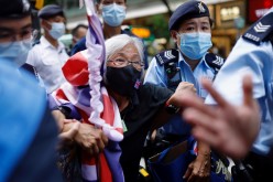 A pro-democracy protester with a Union flag mask is taken by police at Causeway Bay after police denied permission for a protest rally 