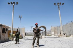 Afghan soldiers stand guard at the gate of Bagram U.S. air base, on the day the last of American troops vacated it, Parwan province, Afghanistan 