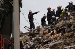 Rescue personnel continue the search and rescue operation for survivors at the site of a partially collapsed residential building in Surfside, near Miami Beach, Florida, U.S