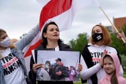 Belarus opposition leader Sviatlana Tsikhanouskaya holds a picture of her husband Syarhei Tsikhanouski during a 