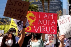 Demonstrators hold signs during a rally against anti-Asian hate crimes outside City Hall in Los Angeles, California, U.S.