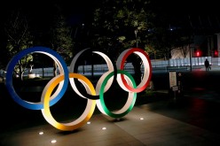 The Olympic rings are illuminated in front of the National Stadium in Tokyo, Japan