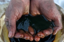 An employee demonstrates a sample of crude oil in the Yarakta Oil Field, owned by Irkutsk Oil Company (INK), in Irkutsk Region, Russia in this picture illustration taken