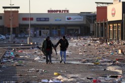Members of a private security walk at a looted shopping mall as the country deploys army to quell unrest linked to the jailing of former South African President Jacob Zuma, in Vosloorus