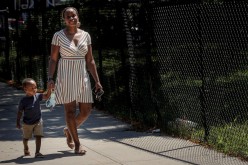 Chantel Springer walks with her son Jasiah in the Brooklyn borough of New York, U.S.,