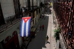 A Cuban flag hangs over a street in downtown Havana, Cuba,