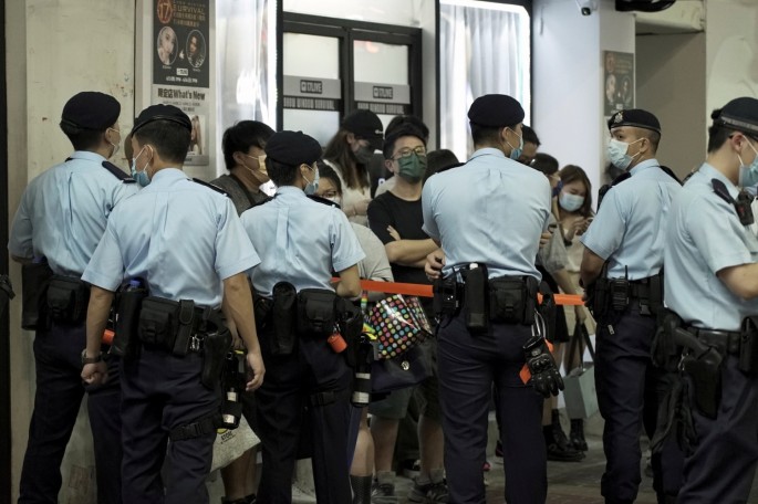 Police officers stop and search residents at Mong Kok district on the 32nd anniversary of the crackdown on pro-democracy demonstrators at Beijing's Tiananmen
