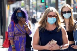 People wearing face protective masks walk on Hollywood Blvd during the outbreak of the coronavirus disease (COVID-19), in Los Angeles, California, U.S