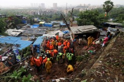 Rescue workers search for survivors after a residential house collapsed due to landslide caused by heavy rainfall in Mumbai, India, 