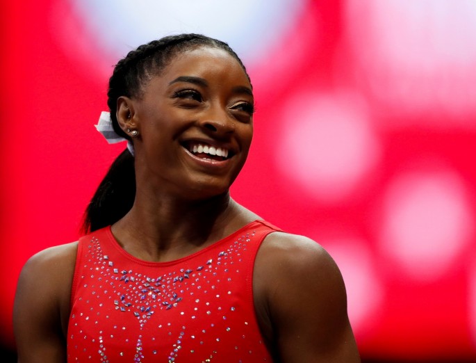 Simone Biles smiles at a teammate during the final day of women's competition in the U.S. Olympic Team Trials for gymnastics in St. Louis, Missouri, U.S.,