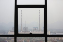 Chimneys are seen through a window at a coal-fired power plant on a hazy day in Shimen county, central China's Hunan Province,