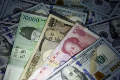 South Korean won, Chinese yuan and Japanese yen notes are seen on U.S. 100 dollar notes in this picture illustration taken in Seoul, South Korea