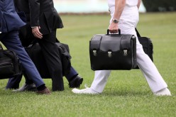A military aide carries the so-called nuclear football as he walks to board the Marine One helicopter with U.S. President Donald Trump for travel to Florida from the White House in Washington,