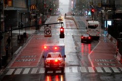 An ambulance drives across a nearly empty East 42nd Street in heavy rain and high winds in Manhattan during the outbreak of the coronavirus disease (COVID-19) in New York City, New York,