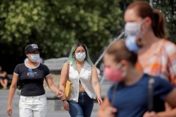 People wear masks, as cases of the infectious Delta variant of coronavirus disease (COVID-19) continue to rise, in Washington Square Park in New York City, U.S.,