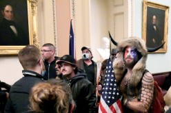 Jacob Anthony Chansley of Arizona stands with other supporters of U.S. President Donald Trump as they demonstrate on the second floor of the U.S. Capitol near the entrance to the Senate