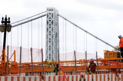 Construction workers are seen at the site of a large public infrastructure reconstruction project of an elevated roadway and bridges in upper Manhattan in New York City,