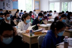 Students wearing face masks are seen inside a classroom during a government-organised media tour at a high school as more students returned to campus following the coronavirus disease (COVID-19) outbreak, in Shanghai,