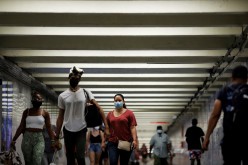 People wear masks as they pass through a pedestrian subway as cases of the infectious coronavirus Delta variant continue to rise in New York City, New York, U.S.,