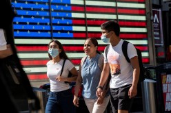 People wear masks around Times Square, as cases of the infectious coronavirus Delta variant continue to rise in New York City,