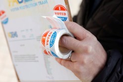 A person holds stickers saying 