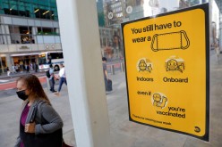 A poster alerting for the wearing of masks is seen on a 42nd Street subway entrance as cases of the infectious coronavirus Delta variant continue to rise in New York City, New York, U.S.