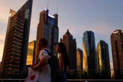 People walk in Lujiazui financial district during sunset in Pudong, Shanghai, China