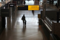 Air travelers walk through a terminal as the coronavirus disease (COVID-19) outbreak continues, at New York’s JFK International Airport in New York, U.S.