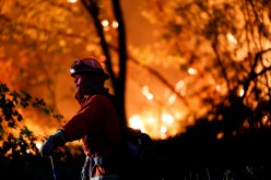 A firefighter monitors flames which were threatening homes by the River Fire, a wildfire near the Placer County town of Grass Valley, California, U.S.