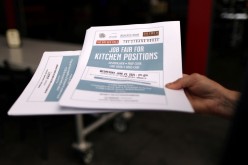 A woman holds fliers for a job fair for restaurant and hotel workers, after coronavirus disease (COVID-19) restrictions were lifted, in Torrance, near Los Angeles, California,