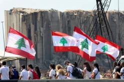 People carry national flags near the site of last year's Beirut port blast, as Lebanon marks the one-year anniversary of the explosion in Beirut,