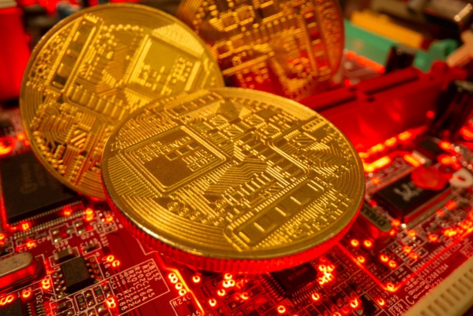 Representations of the virtual currency stand on a motherboard in this picture illustration taken