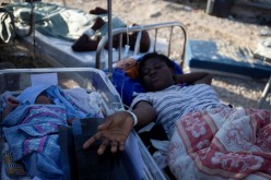 A woman on a stretcher is pictured with a baby after a 7.2 magnitude earthquake in Les Cayes, Haiti 