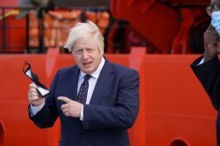 Britain's Prime Minister Boris Johnson gestures before boarding the vessel Alba in Fraserburgh Harbour, which will transport him to the Moray Offshore Windfarm East during his visit to Scotland,